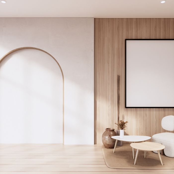 Minimalistisch interieur met een witte boogvormige deuropening, houten wandpanelen en een groot leeg fotolijstje. De ruimte omvat een ronde witte salontafel met een plant, een kleine houten tafel en een witte stoel op een beige kleed. Decoratief aardewerk accentueert het gebied, wat doet denken aan serene schildersstudio’s. Minimalistisch interieur met een witte boogvormige deuropening, houten wandpanelen en een groot leeg fotolijstje. De ruimte omvat een ronde witte salontafel met een plant, een kleine houten tafel en een witte stoel op een beige kleed. Decoratief aardewerk accentueert het gebied, wat doet denken aan serene schildersstudio's.